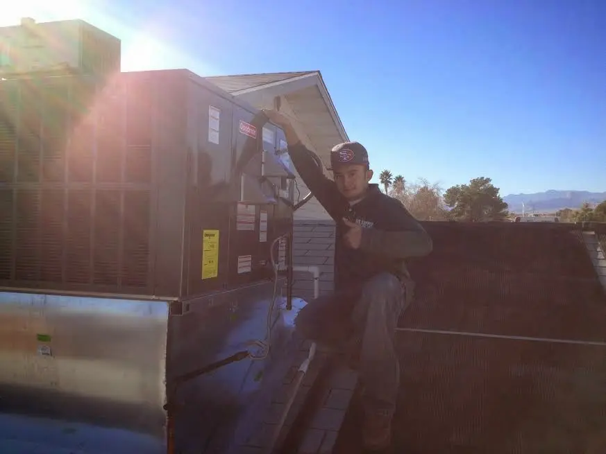 HVAC technician performing AC Tune-Up on a rooftop unit in Eden Isle